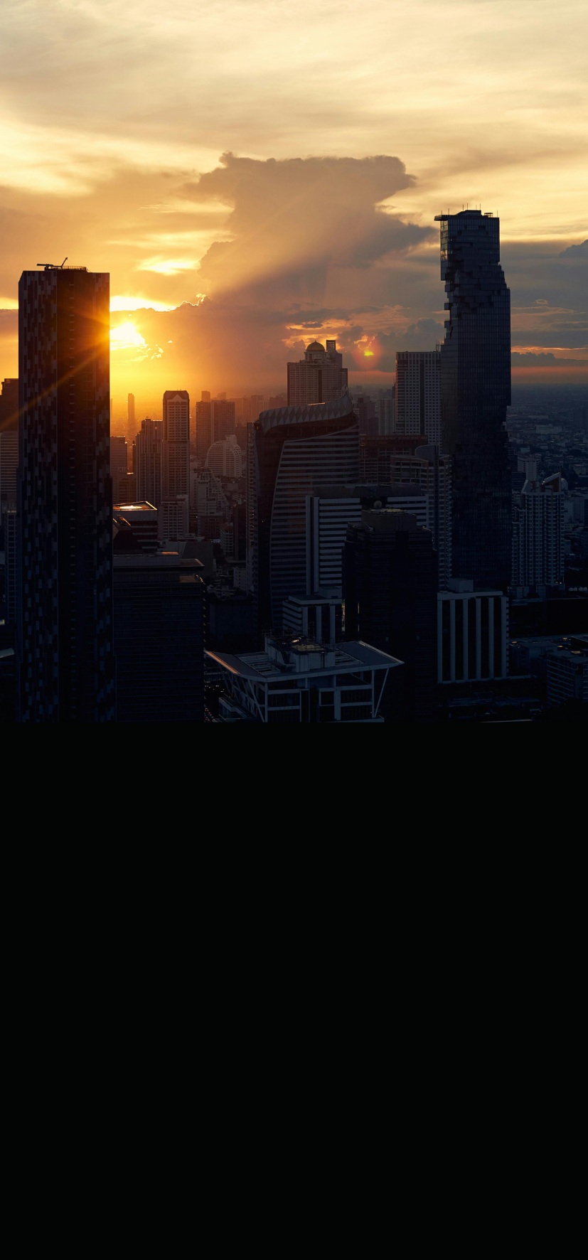City skyline at sunset, representing scale and ambition